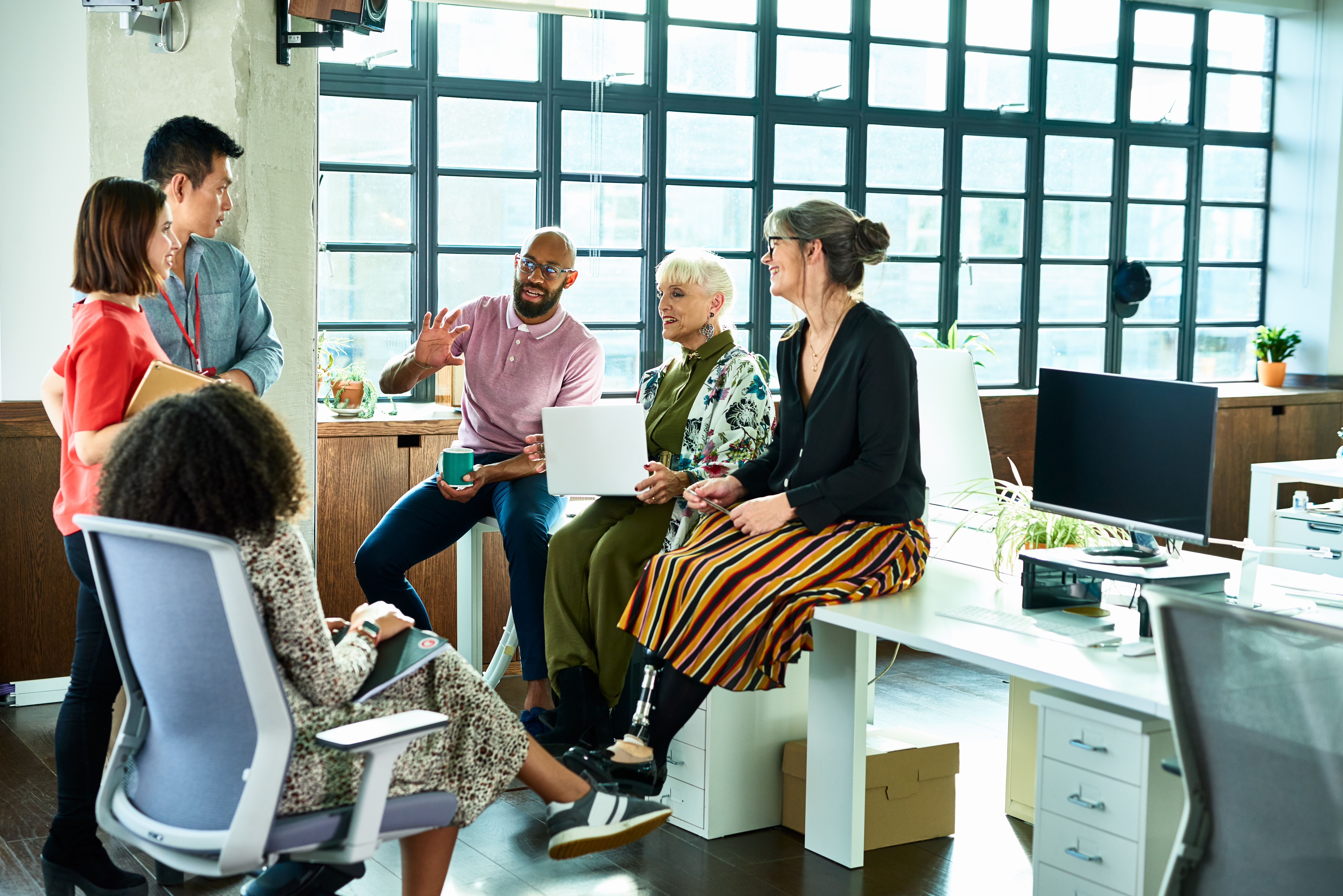 Group of colleagues at work chatting together