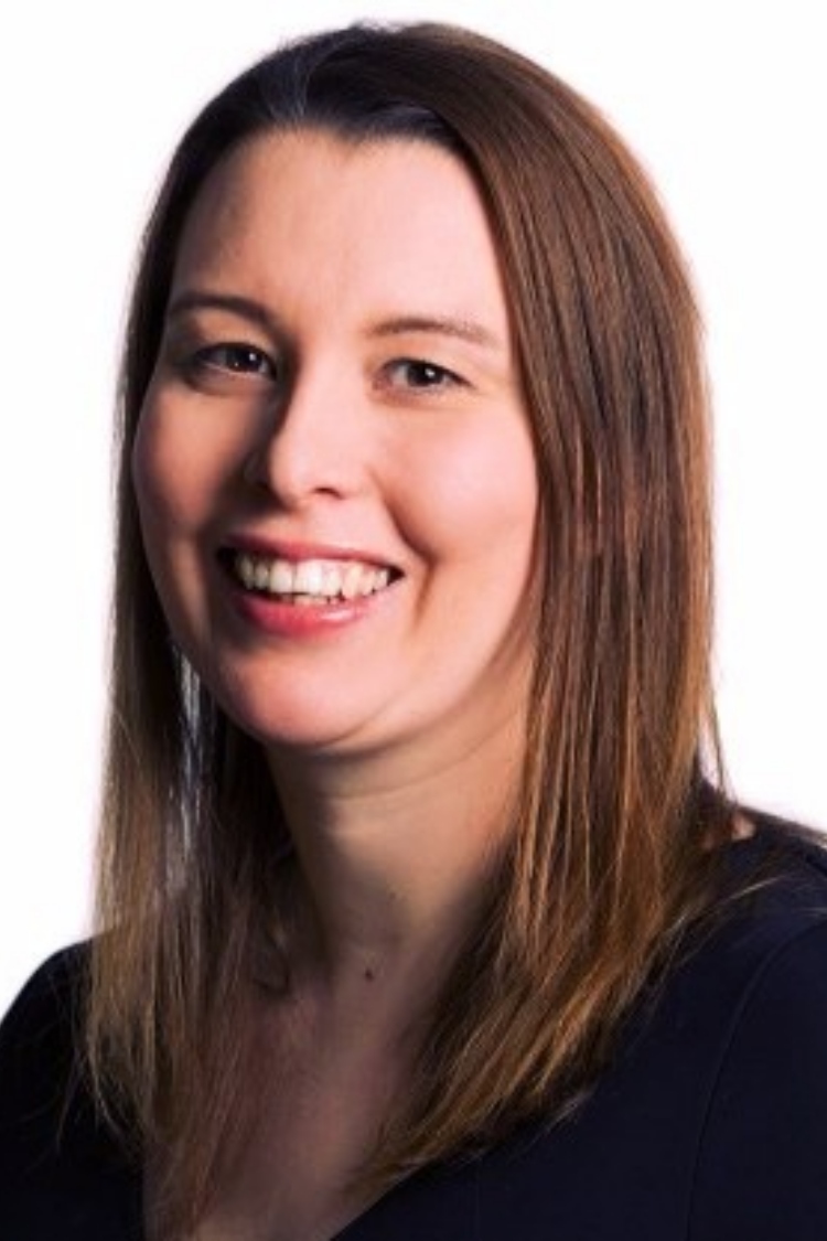 A headshot of Frances smiling at the camera.  She is wearing a black shirt. 